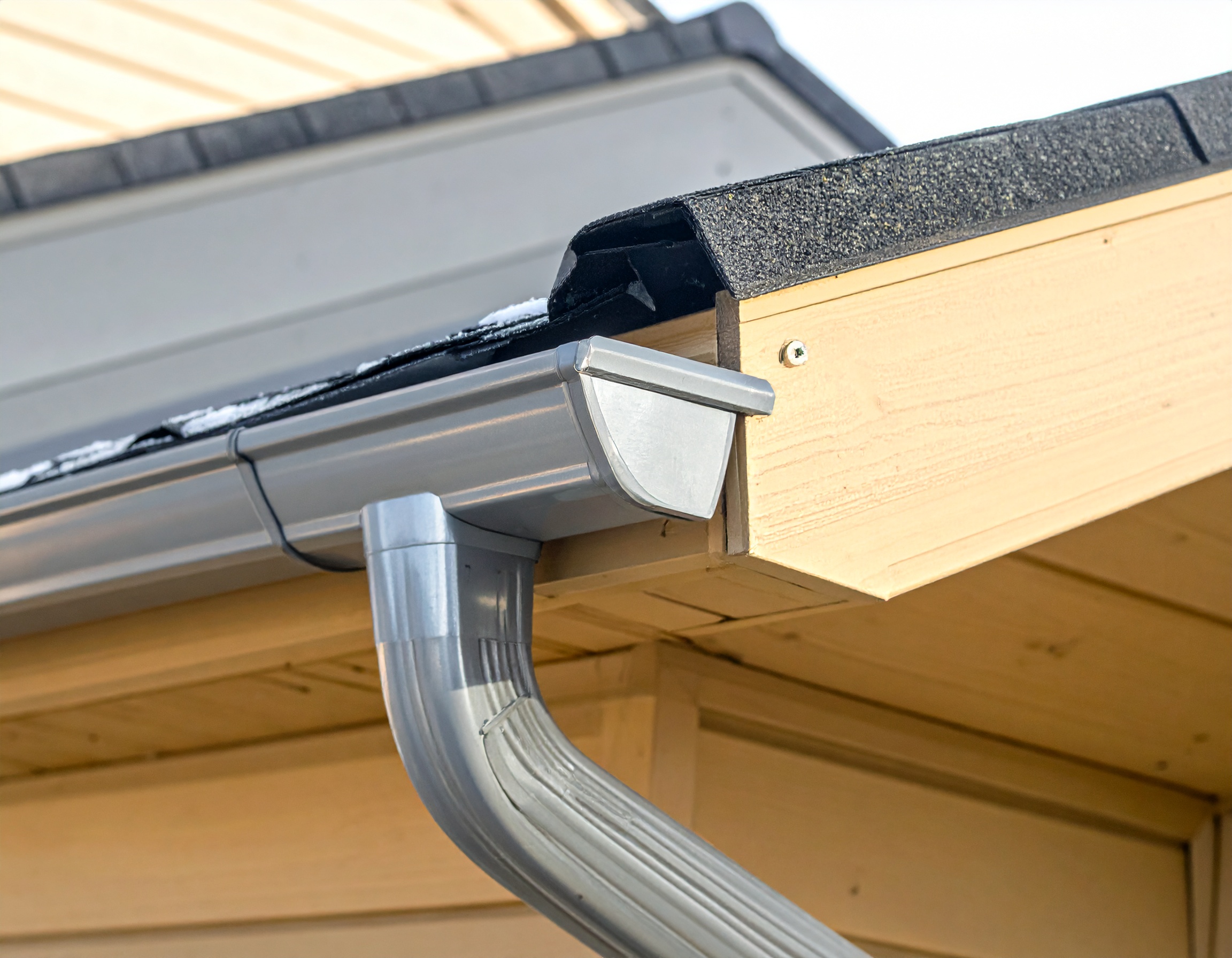 Gutter and downspout close-up after debris removal and maintenance