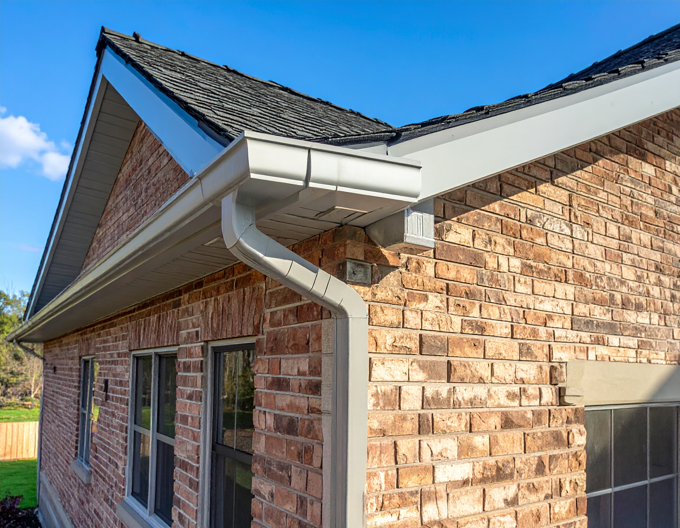 Professional seamless gutter installation along a residential roofline